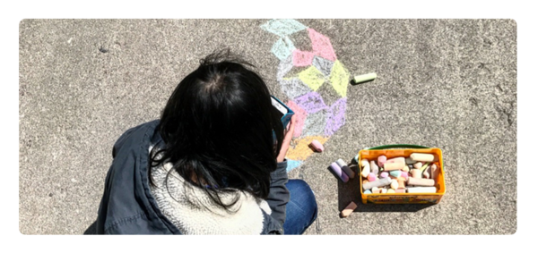 Student working with chalk to participate in the annual sidewalk theorem contest.